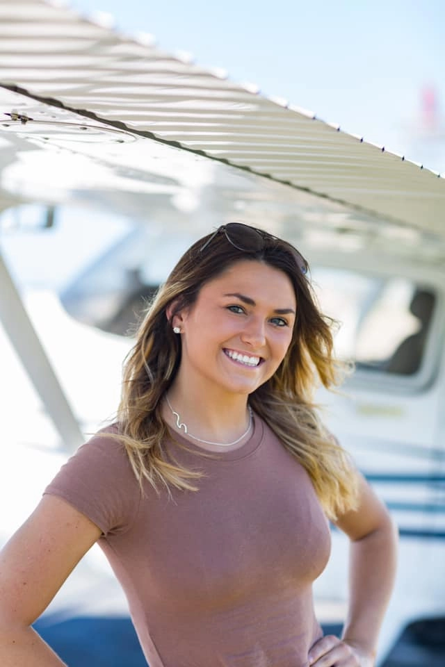 Universal flight school student posing in front of plane