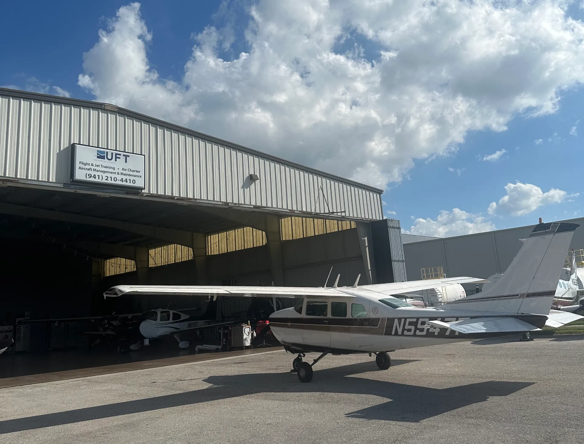 Universal Flight Training hangar with airplane in front, blue sky, day in Sarasota, Florida