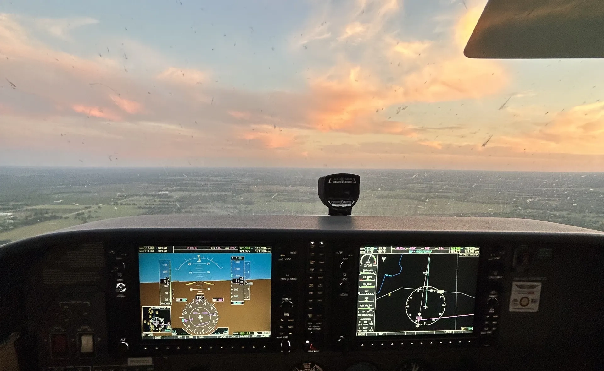 Sunset seen from the cockpit front window of flying airplane