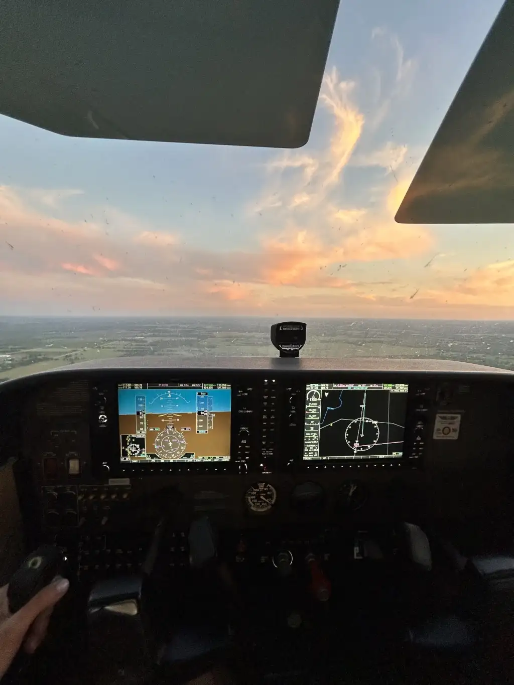 Sunset seen from the cockpit front window of flying airplane