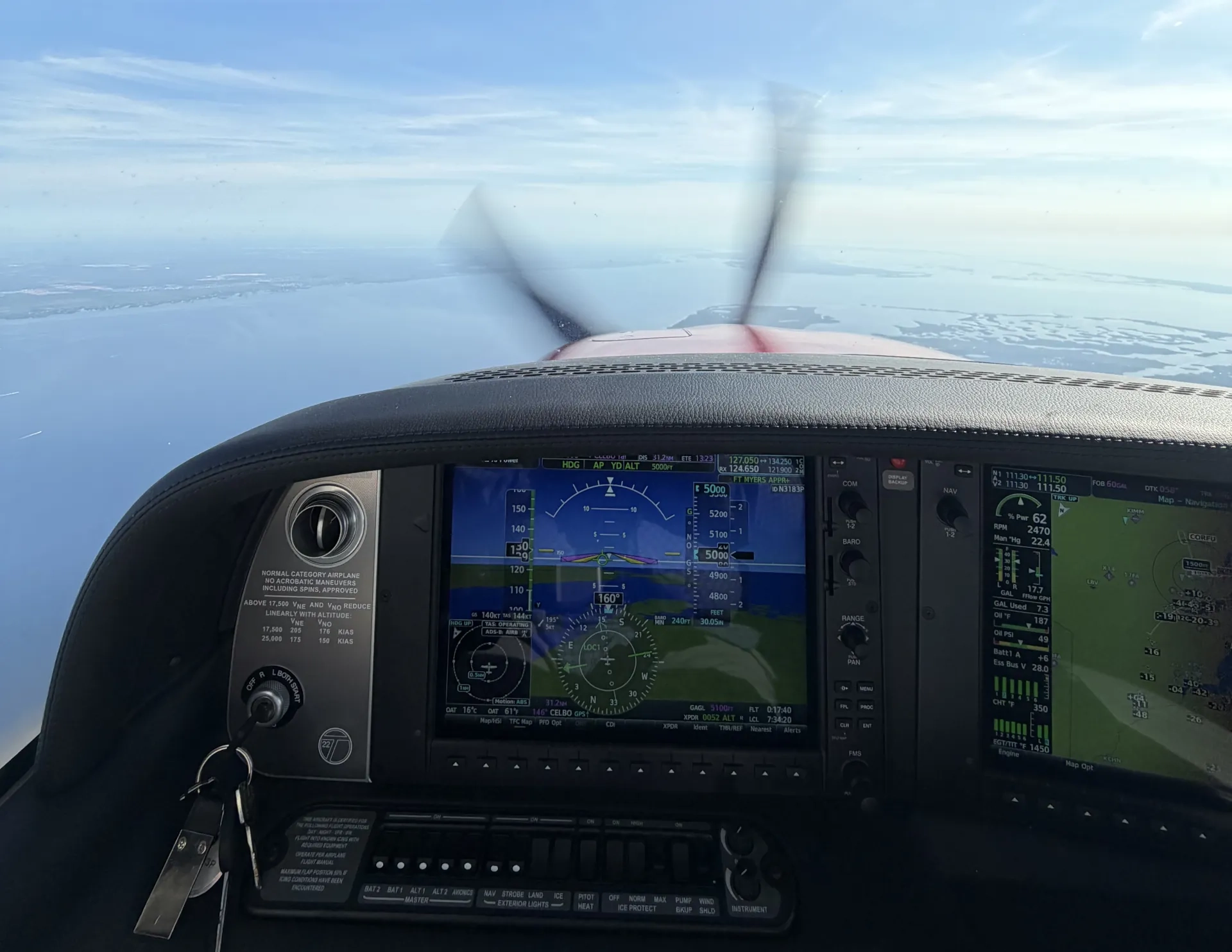 Instrument panel and sea below seen from cockpit of flying plane