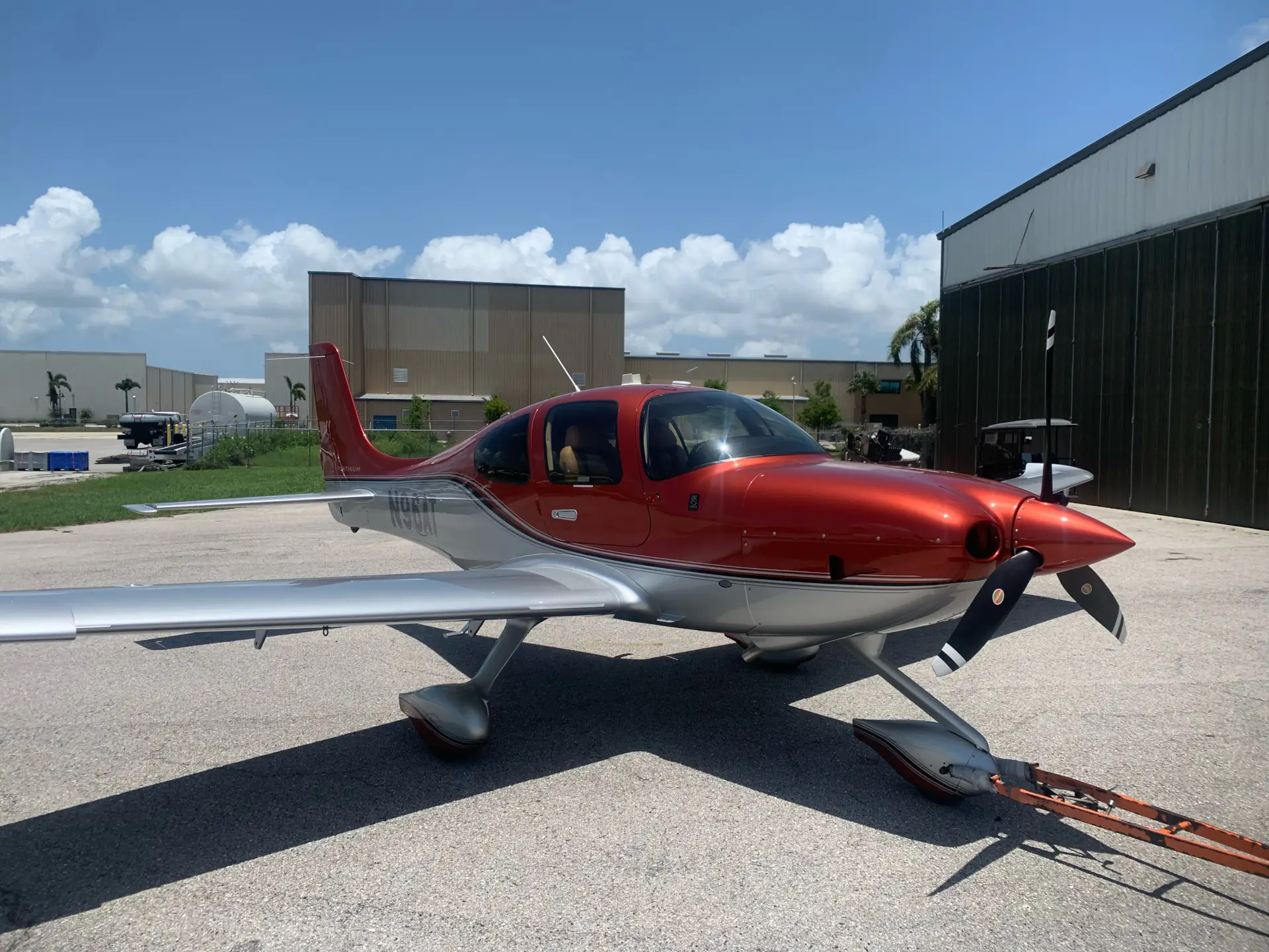 Cirrus SR22 tail number N9AT aircraft on runway in front of hangar during the day