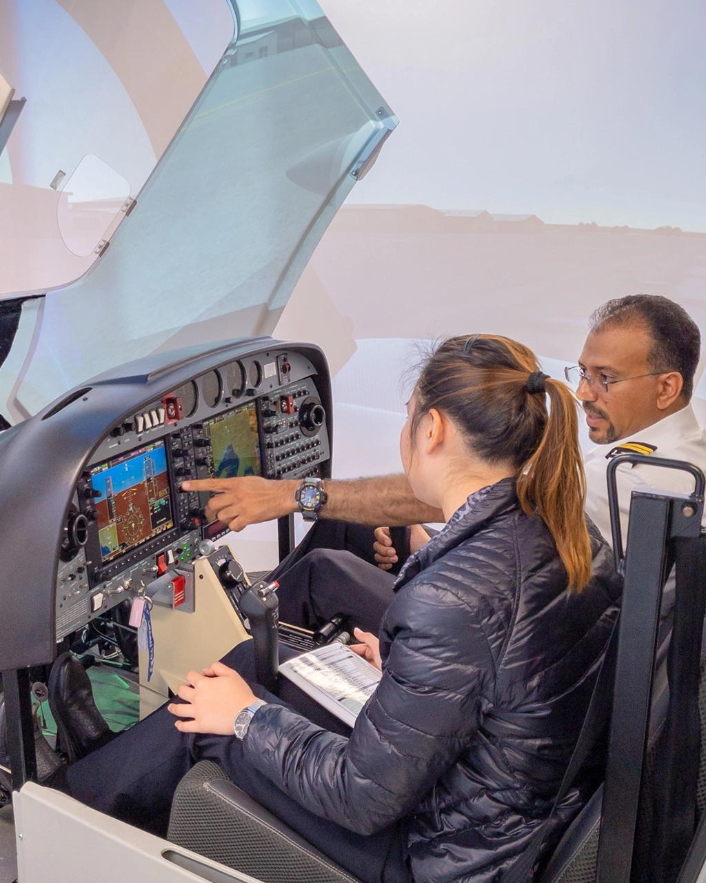 Instructor making explanation to student inside flight simulator